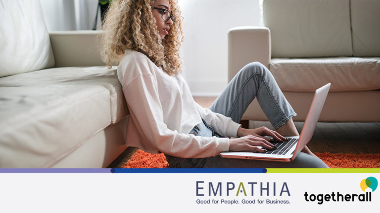 togetherall-press-release Woman typing on a computer with a concerned look on her face.