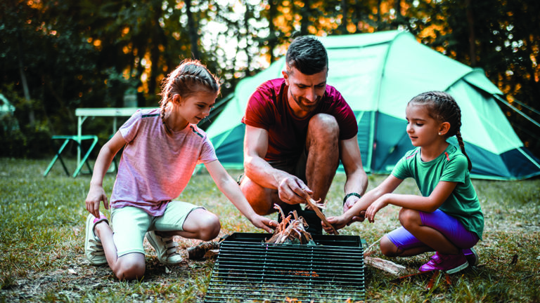 vacation-budget-tips-featured-image Father and daughters camping in beautiful nature