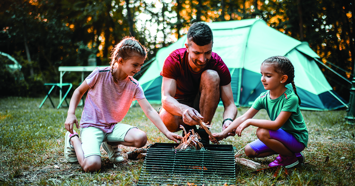 vacation-budget-tips-featured-image Father and daughters camping in beautiful nature